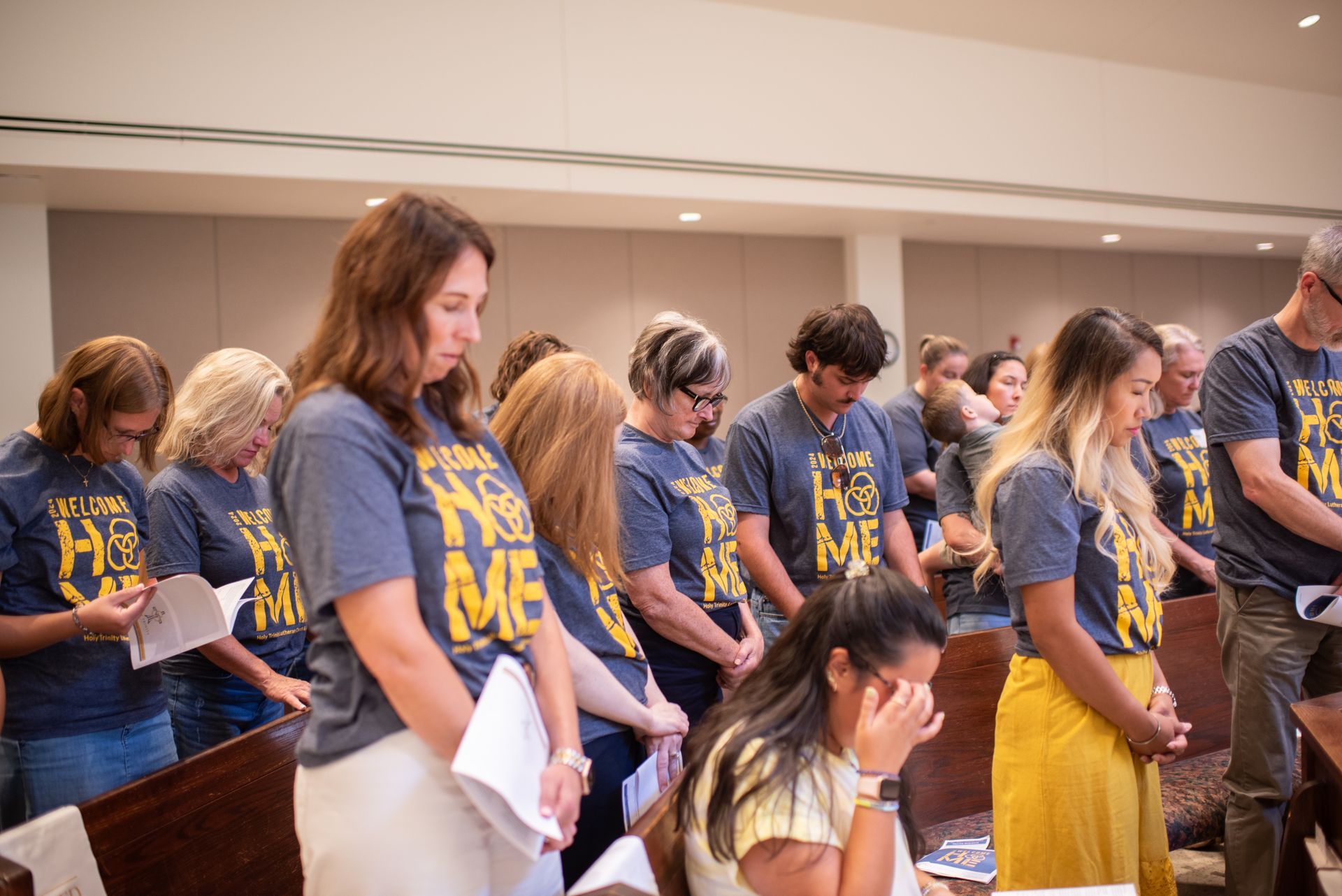 A group of people are praying together in a church.