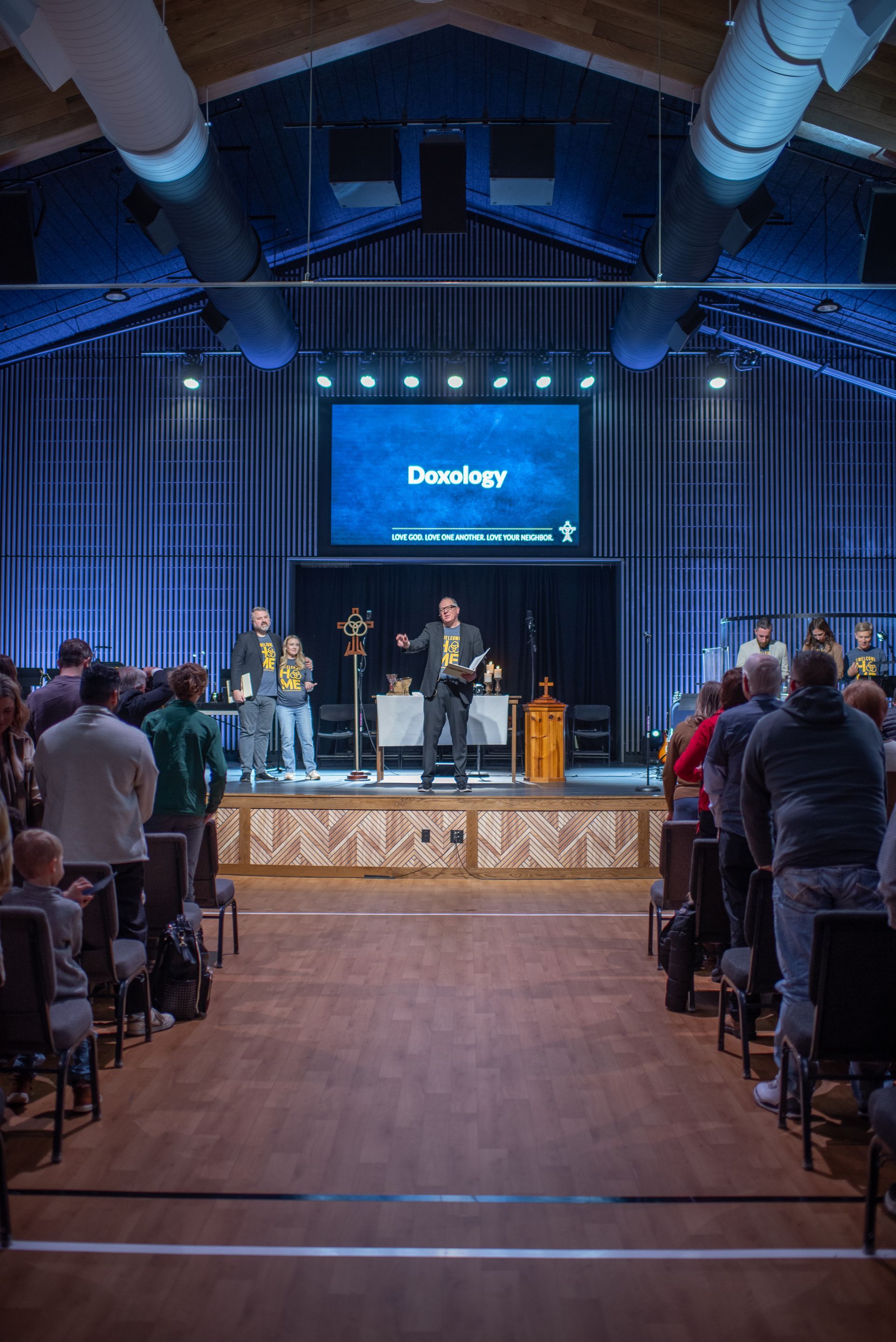 A man is giving a speech in front of a large crowd in a church.