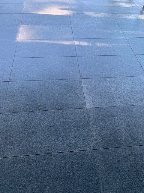 A Close Up of a Tiled Floor With a Shadow on It — The Tile & Stone Specialists in Peregian Beach, QLD
