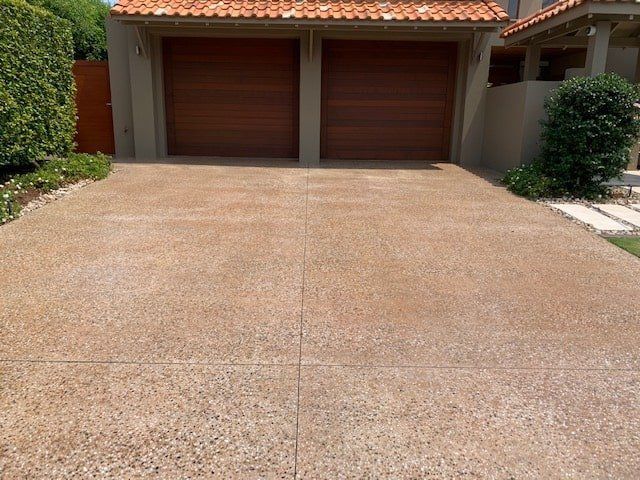 A Driveway Leading to a House With Two Garage Doors — The Tile & Stone Specialists in Peregian Beach, QLD