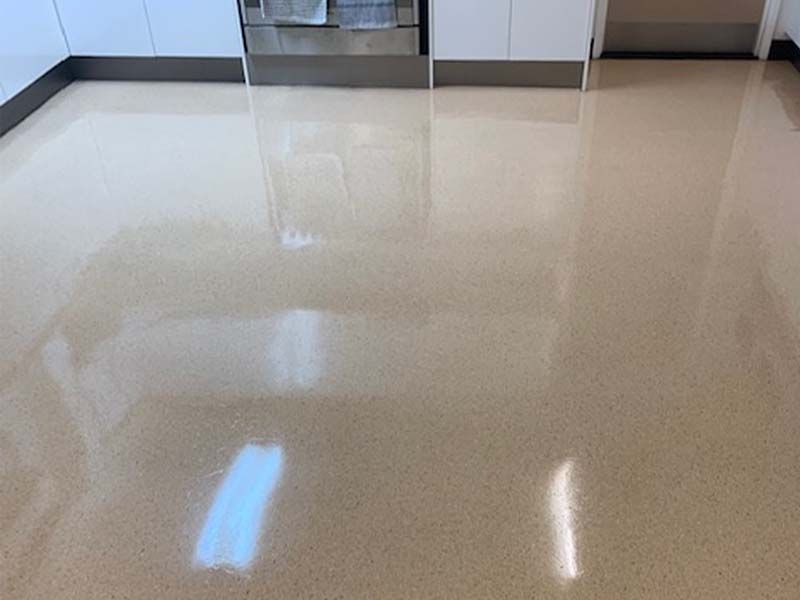 A Kitchen With a Shiny Floor and White Cabinets — The Tile & Stone Specialists in Peregian Beach, QLD