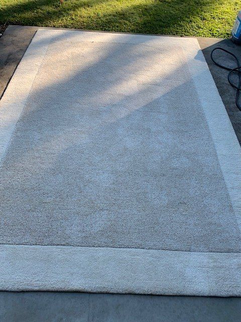 A White Rug is Sitting on Top of a Concrete Floor — The Tile & Stone Specialists in Peregian Beach, QLD