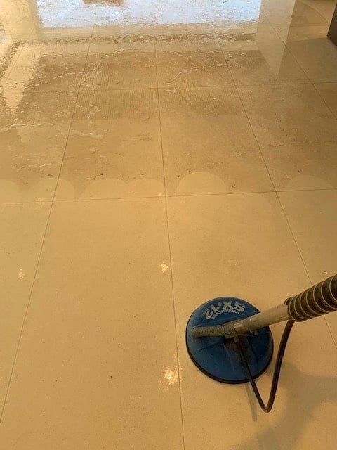 A Vacuum Cleaner is Cleaning a Tile Floor in a Room — The Tile & Stone Specialists in Peregian Beach, QLD