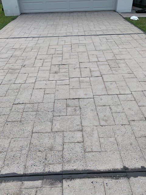 A Brick Driveway With a Garage Door in the Background — The Tile & Stone Specialists in Peregian Beach, QLD