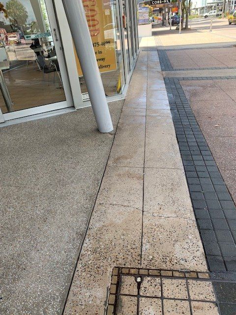 A Sidewalk With a Manhole Cover in the Middle of It — The Tile & Stone Specialists in Peregian Beach, QLD