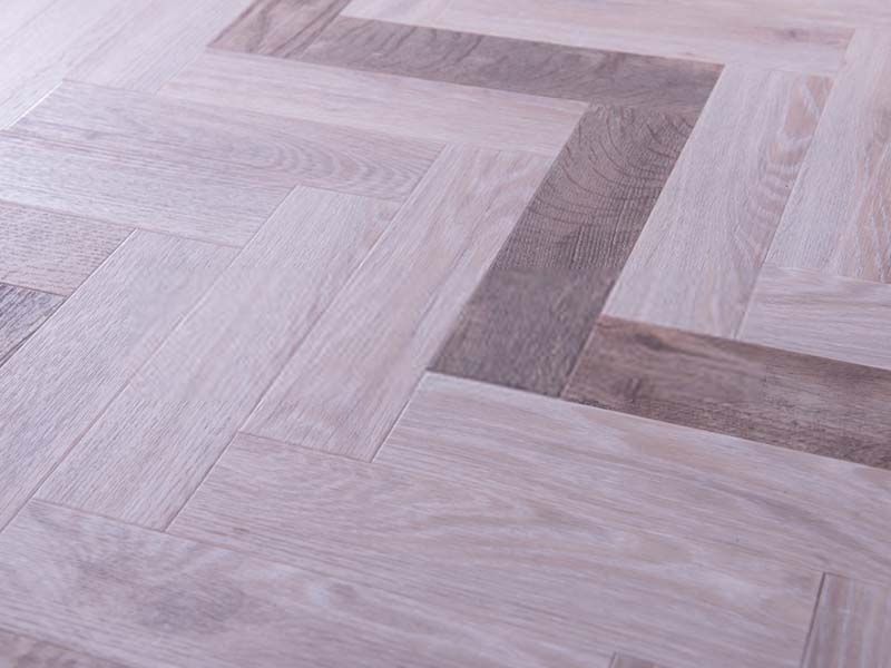 A Close Up of a Wooden Floor With a Herringbone Pattern — The Tile & Stone Specialists in Peregian Beach, QLD