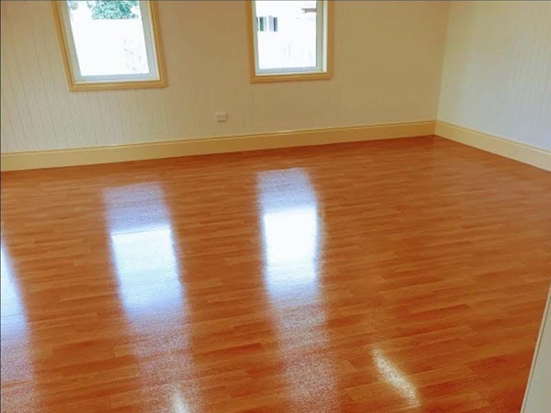 An Empty Room With a Wooden Floor and Three Windows — The Tile & Stone Specialists in Peregian Beach, QLD