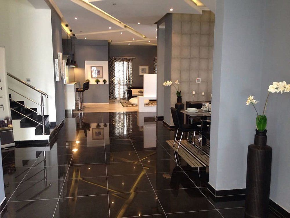 A Large Room With a Black Tile Floor and a Staircase — The Tile & Stone Specialists in Peregian Beach, QLD
