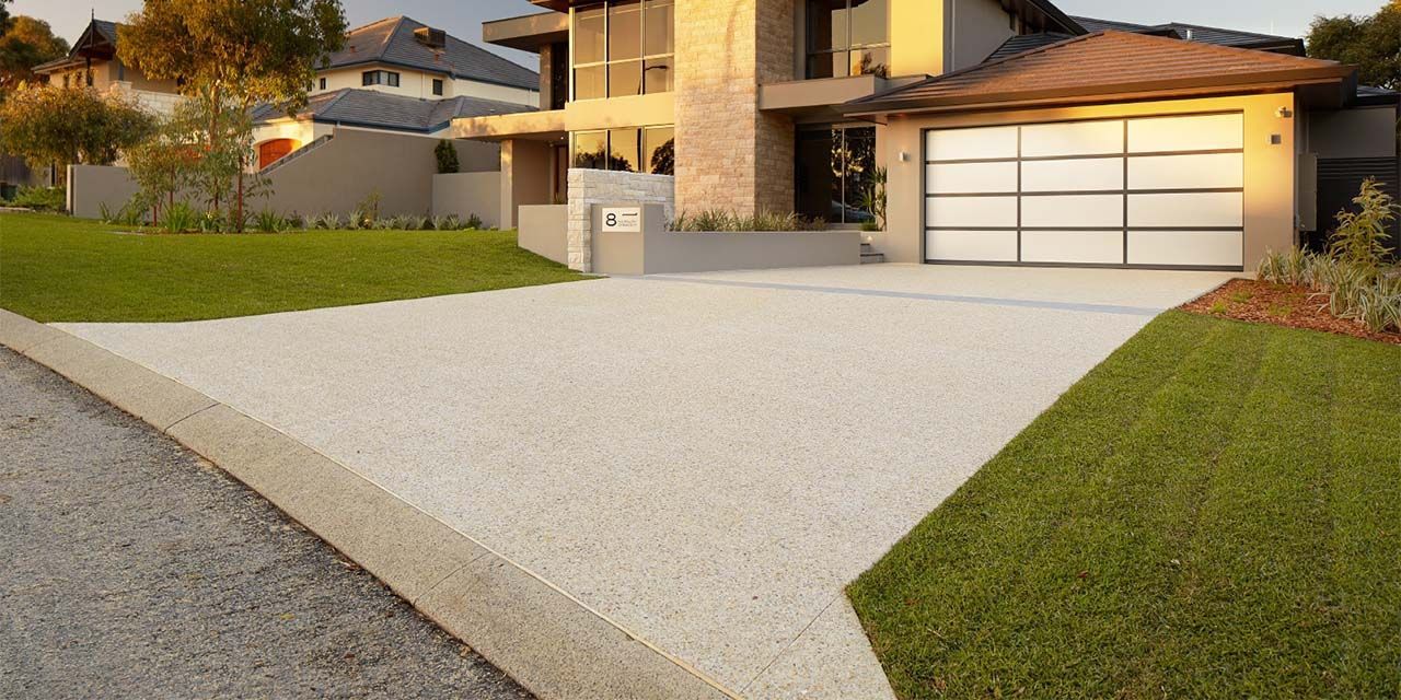 A Driveway Leading to a Large House With a Garage Door — The Tile & Stone Specialists in Maroochydore, QLD