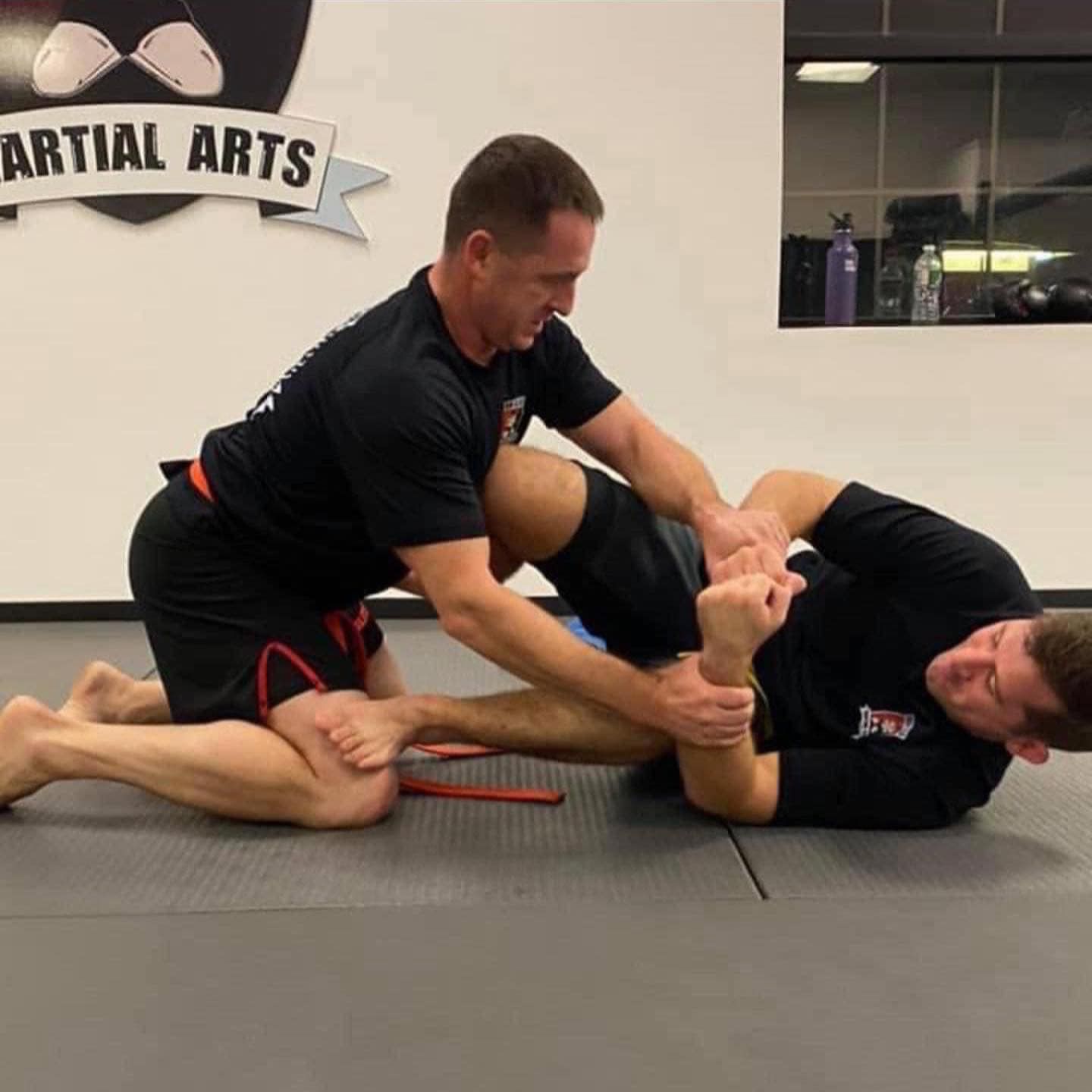 Two men are practicing martial arts in a gym