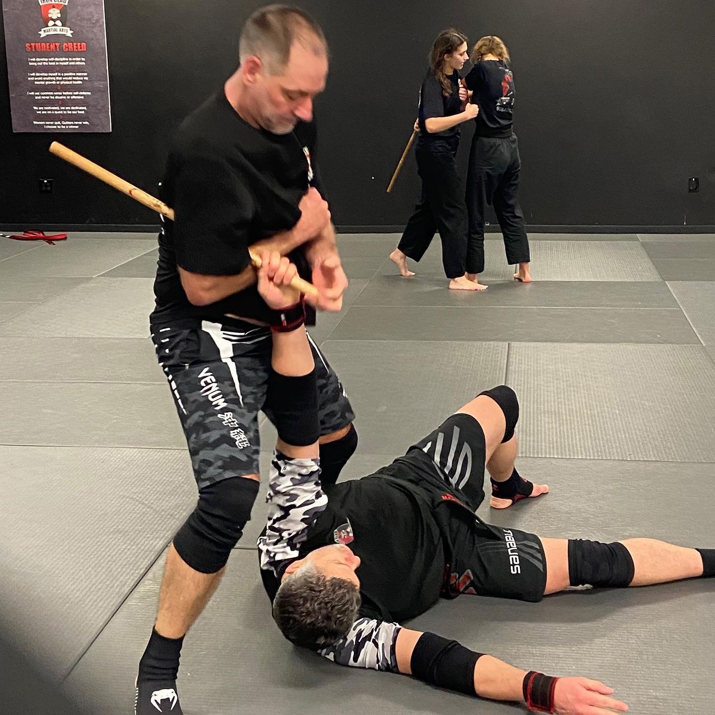 A group of people are practicing martial arts in a gym.