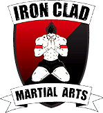 A logo for iron clad martial arts with a man on a shield.