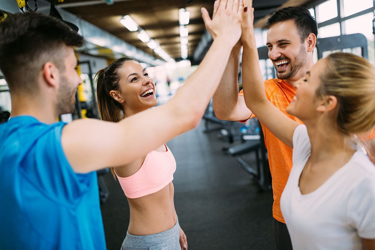 A group of people are giving each other a high five in a gym.