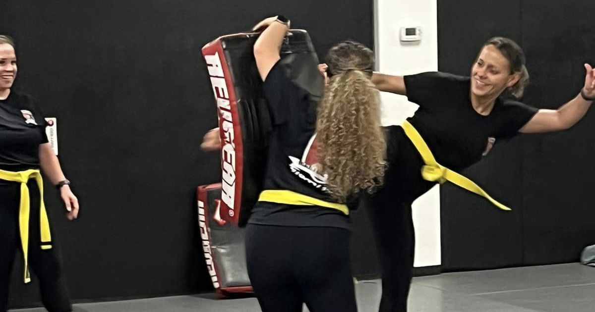 A group of women are practicing martial arts in a gym.