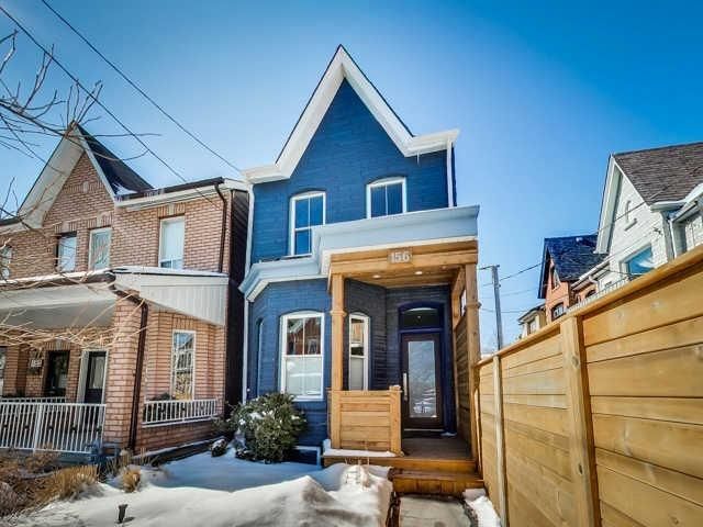 A blue house with a wooden fence in front of it