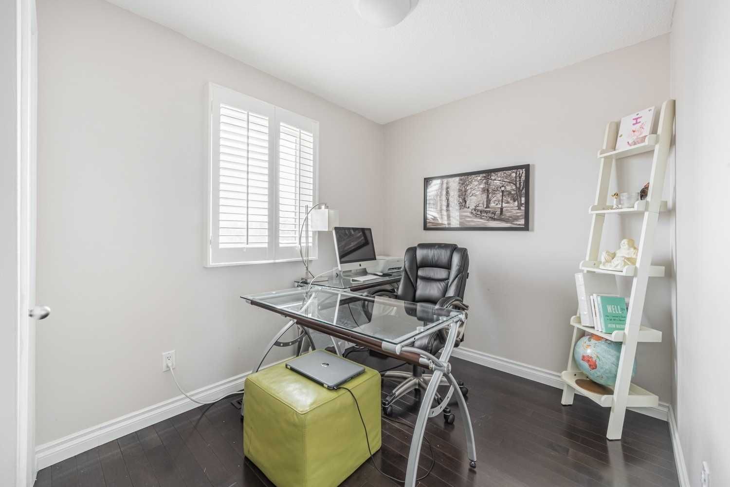 A home office with a desk , chair , computer and ladder.