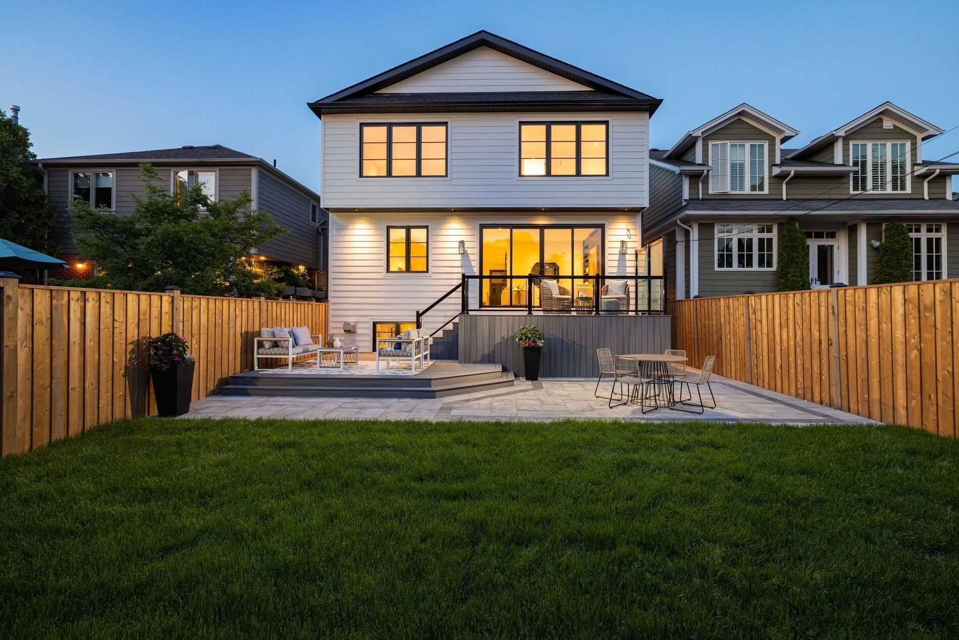 The backyard of a house with a wooden fence and a patio.