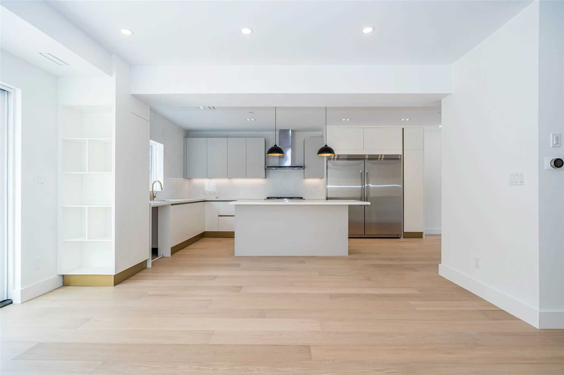 An empty kitchen with a large island in the middle of the room.