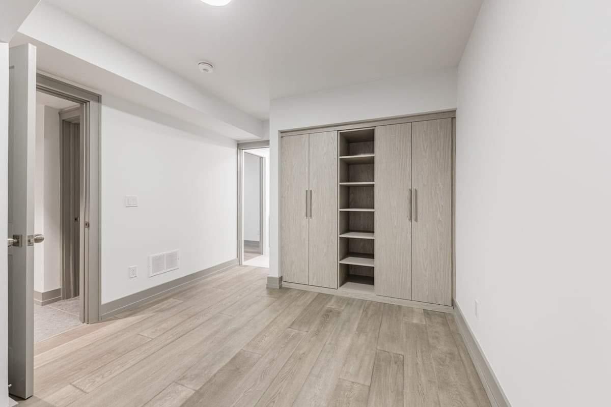 An empty room with hardwood floors and white walls.