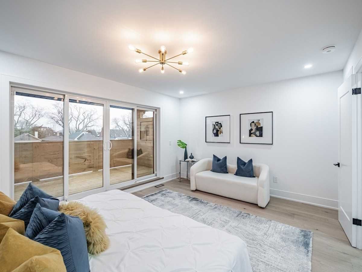 A bedroom with a bed , couch , and sliding glass doors.