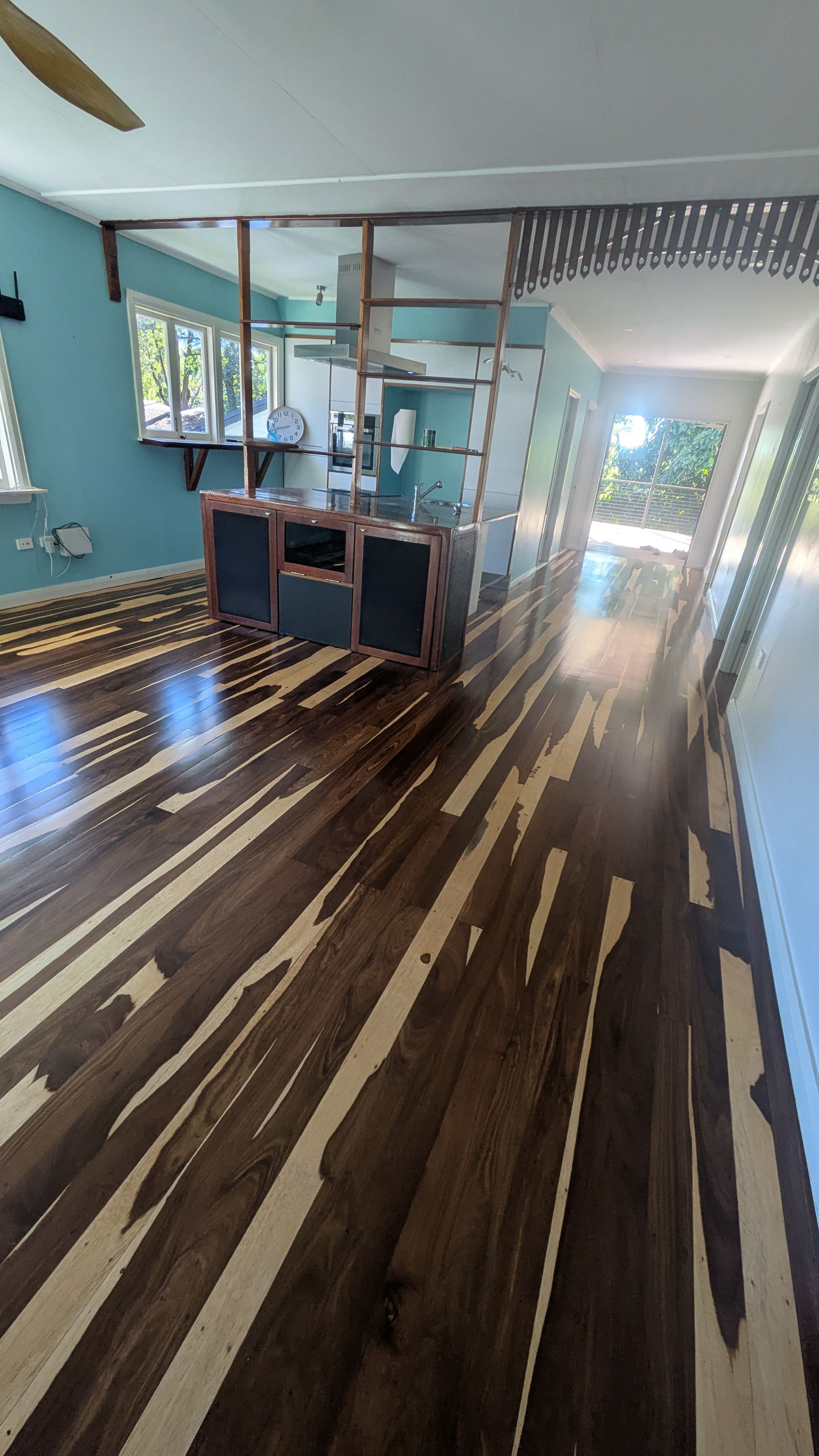 Wooden floors with a striking dark and light pattern lead to an arched doorway.