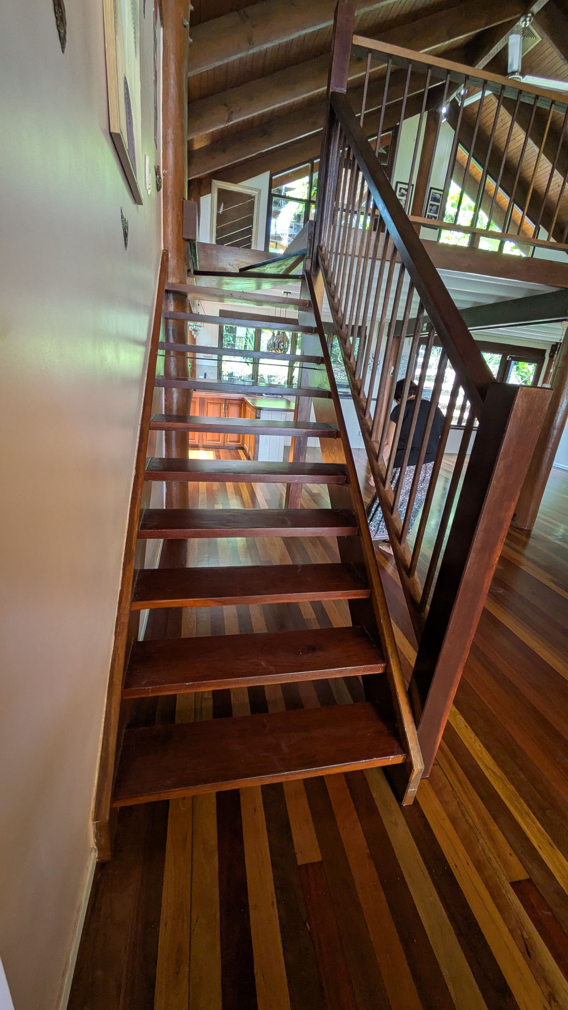 Wooden staircase with dark brown treads and railing. Interior view.