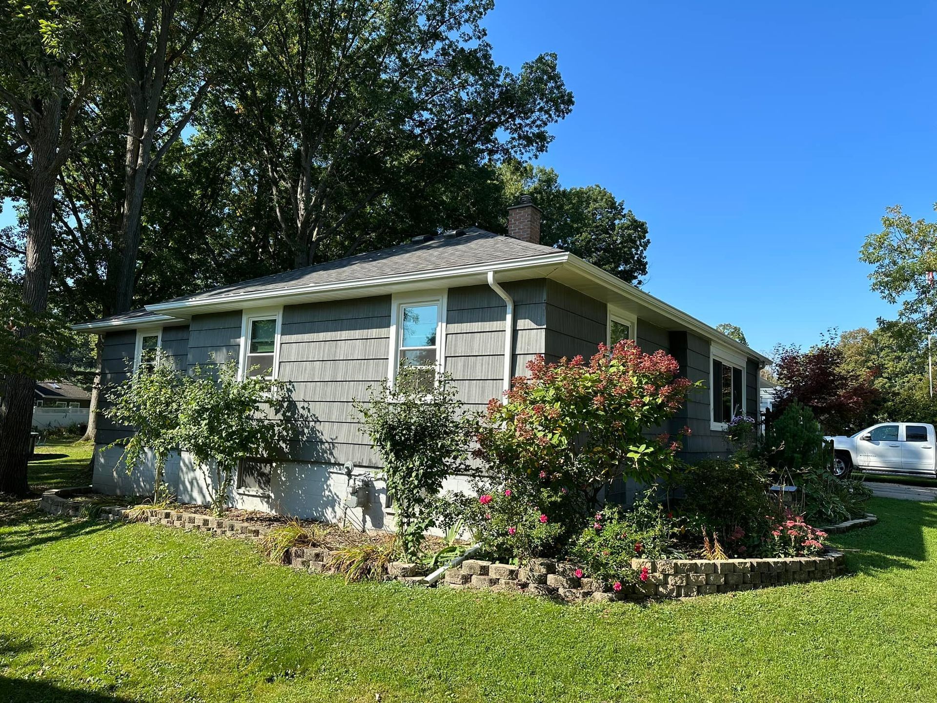 A small house with a lot of windows and a truck parked in front of it.
