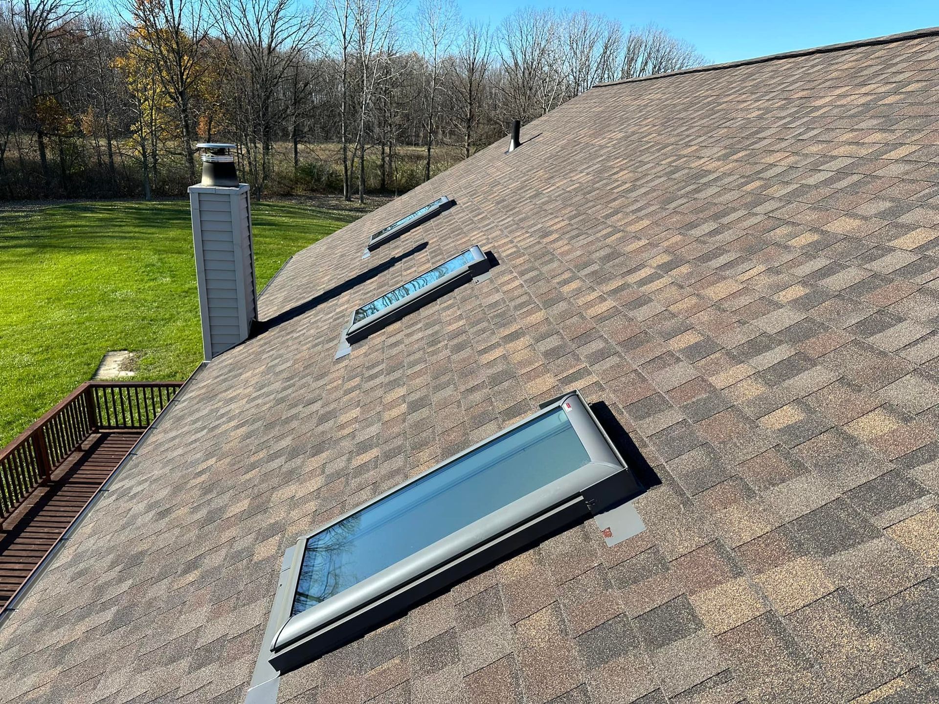 There are three skylights on the roof of a house.