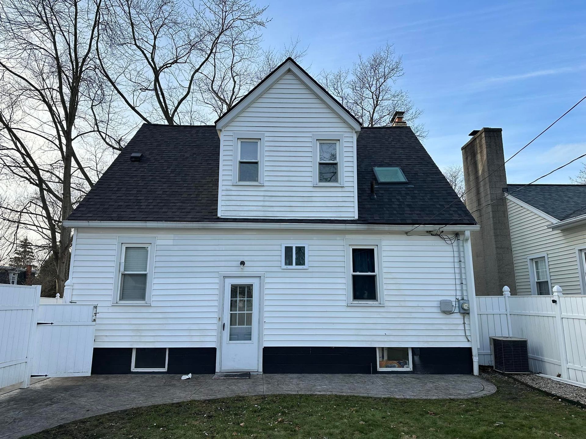 The back of a white house with a black roof