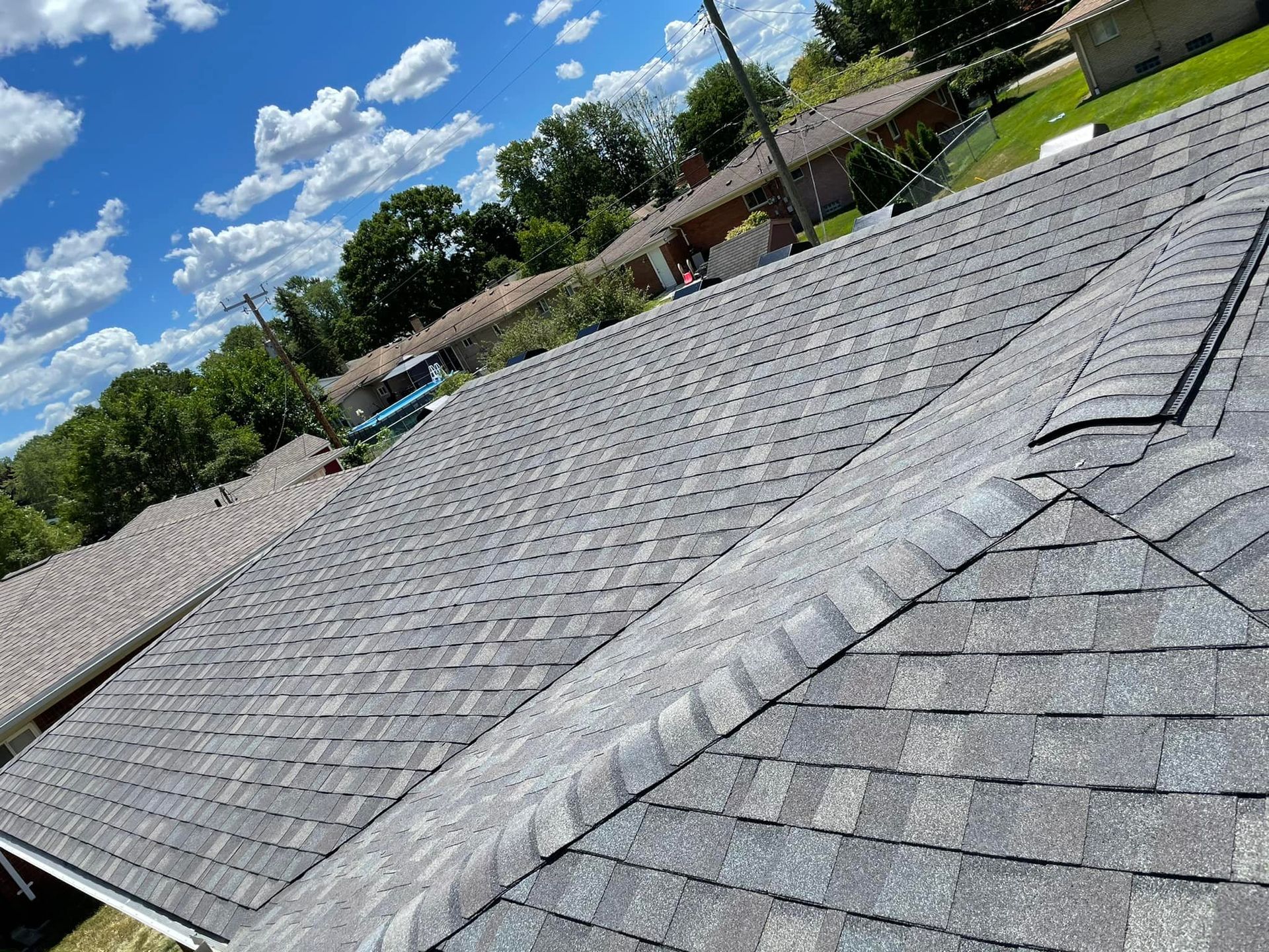 A roof with a lot of shingles and a blue sky in the background.