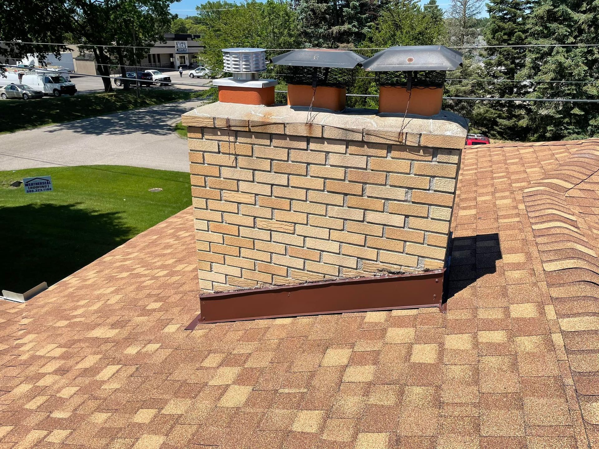 A brick chimney is sitting on top of a roof.