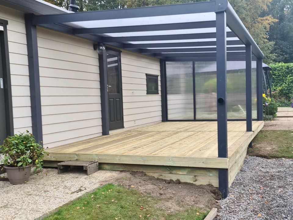 Een huis met een houten terras en een helder dak