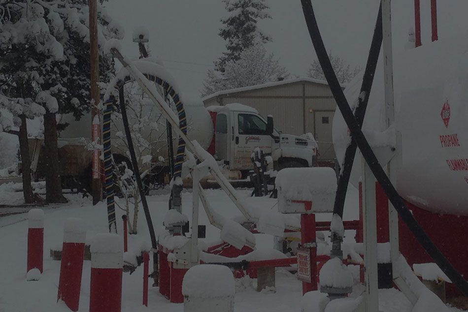 A truck is parked in the snow in front of a building.