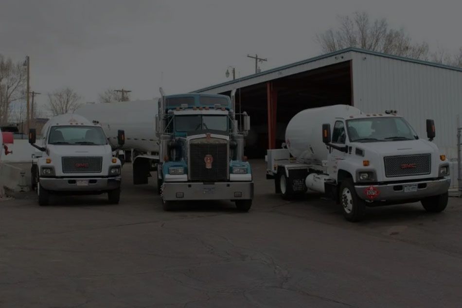 Three trucks are parked in front of a building.