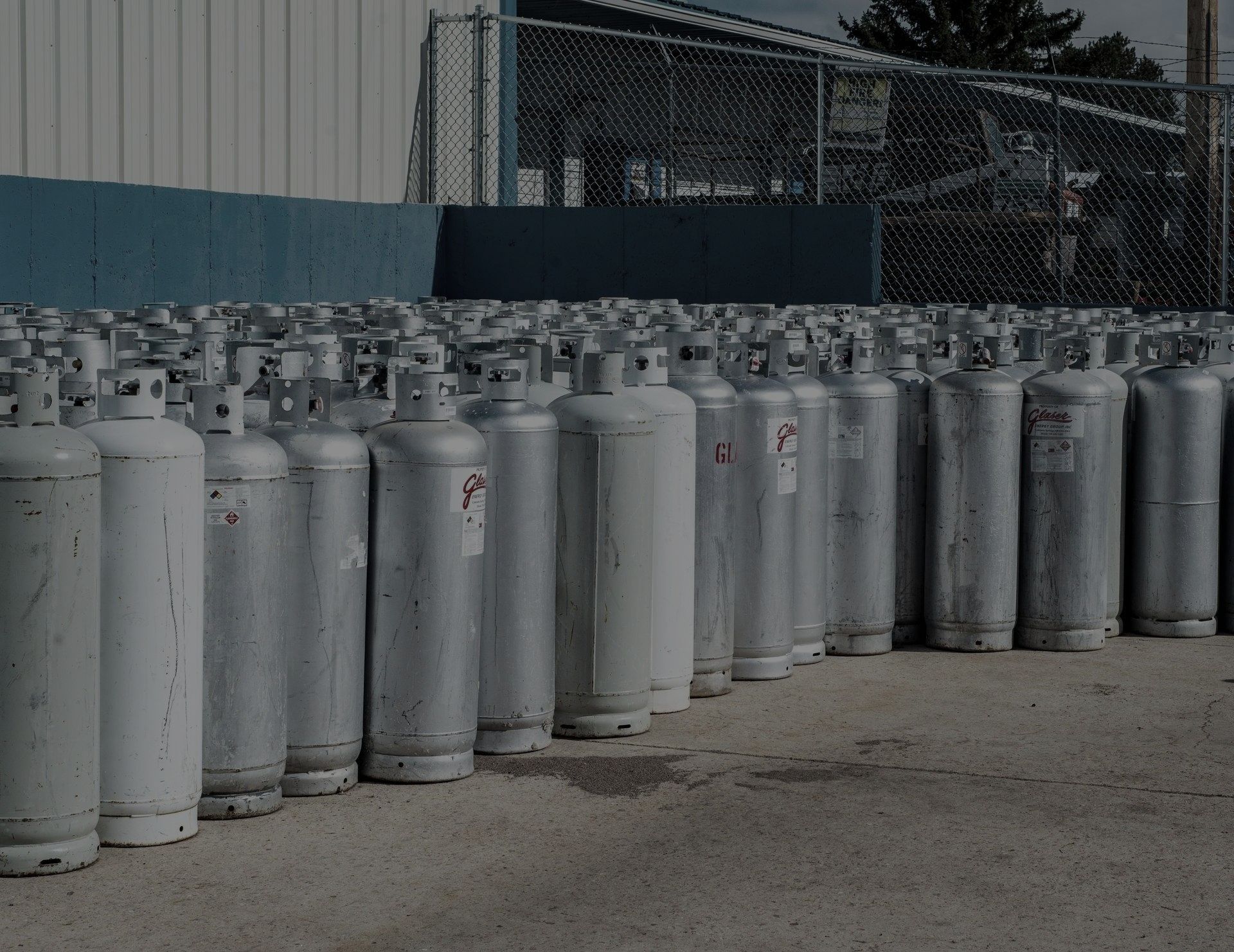 A blue semi truck with a white trailer is parked in a parking lot.