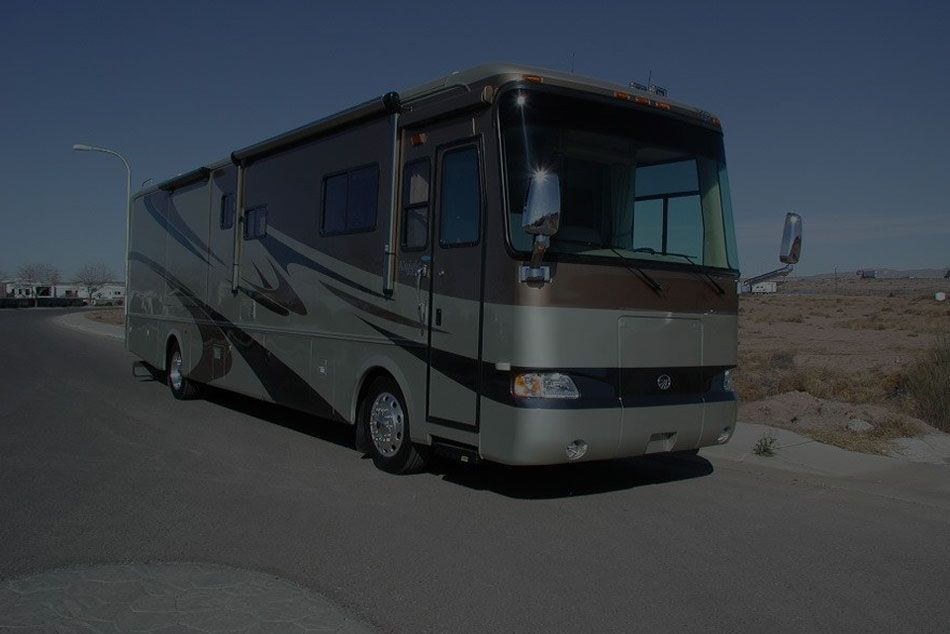 A large rv is parked on the side of the road.
