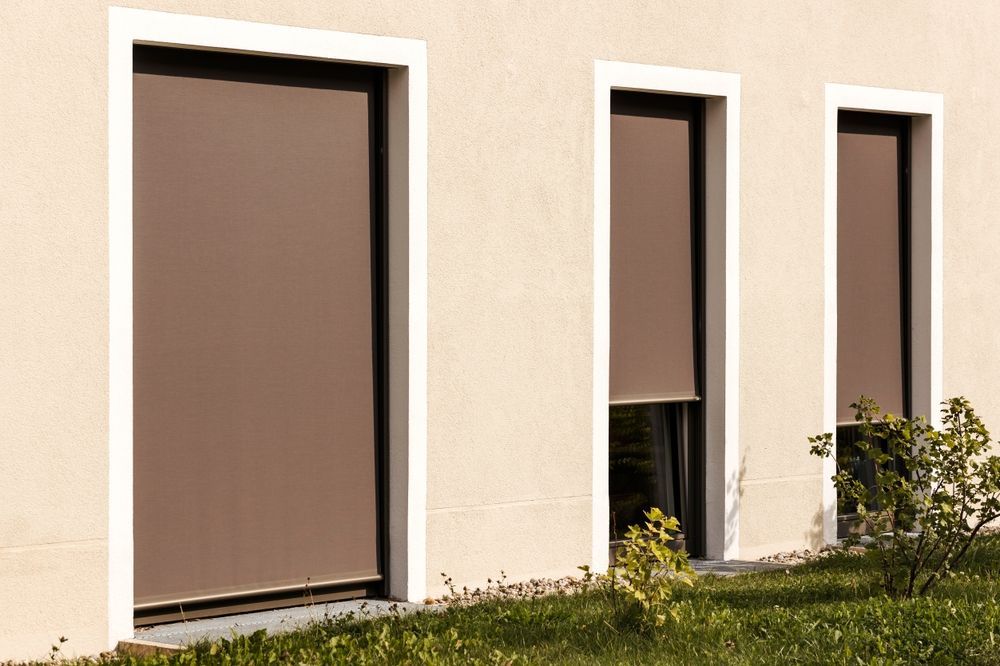 Brown Outdoor Roller Shades on Three Windows of a Beige Building — GV Blinds in Shepparton, VIC