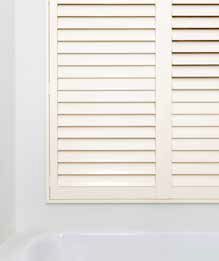 White Bathroom Shutters Above a White Bathtub, Set in a White-walled Room — GV Blinds in Shepparton, VIC