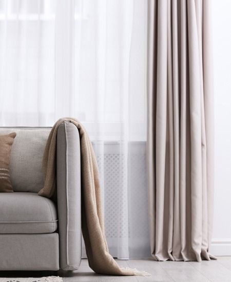 Beige Sofa With a Blanket Draped Over It — GV Blinds in Shepparton, VIC