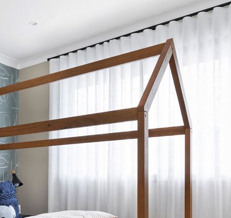Wooden House-shaped Bed Frame in Front of White Sheer Curtains — GV Blinds in Shepparton, VIC