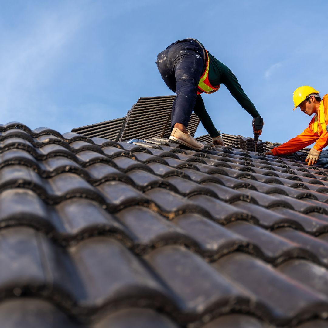 Two men are working on the roof of a building