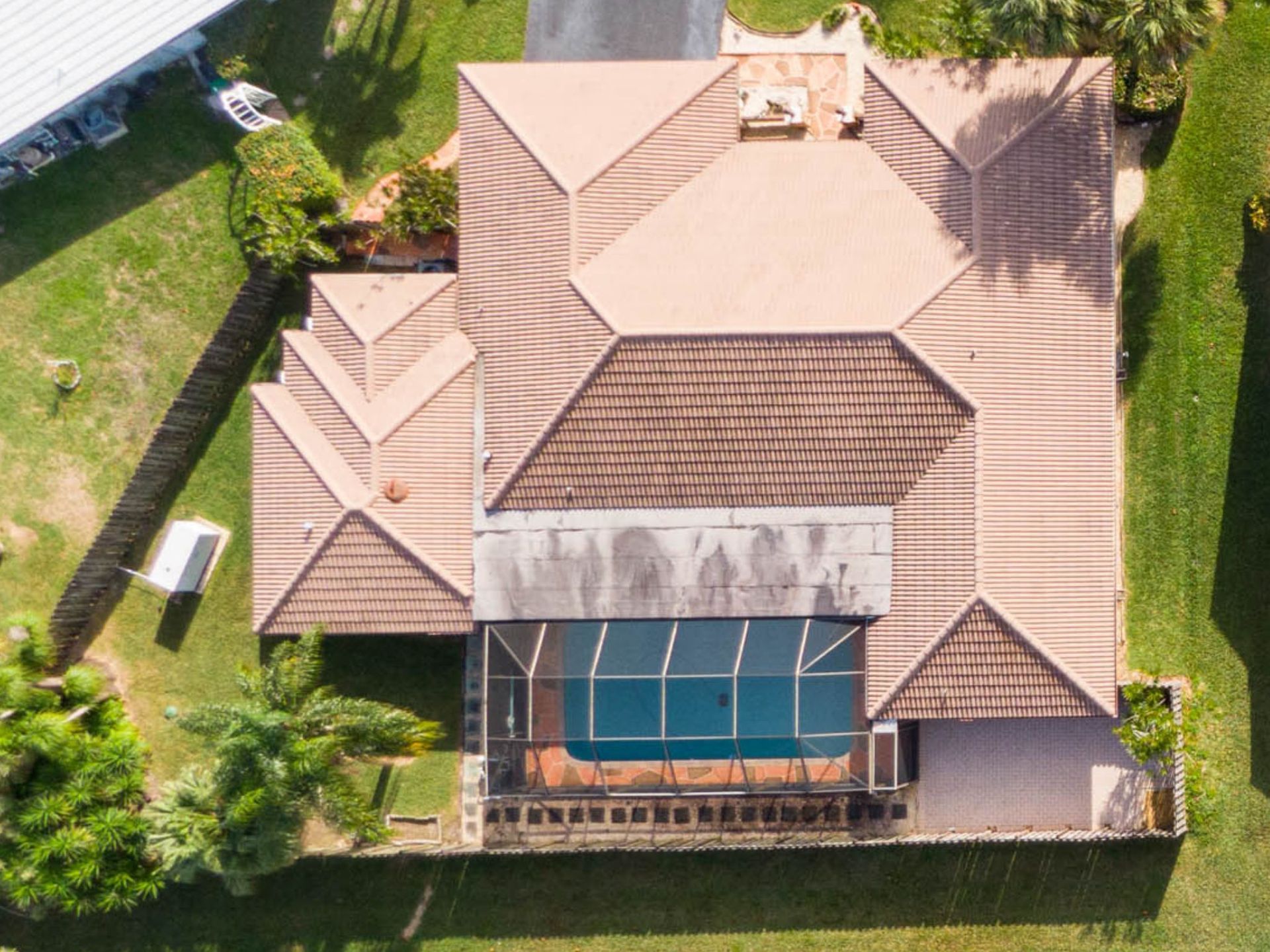 An aerial view of a large house with a pool in the backyard.