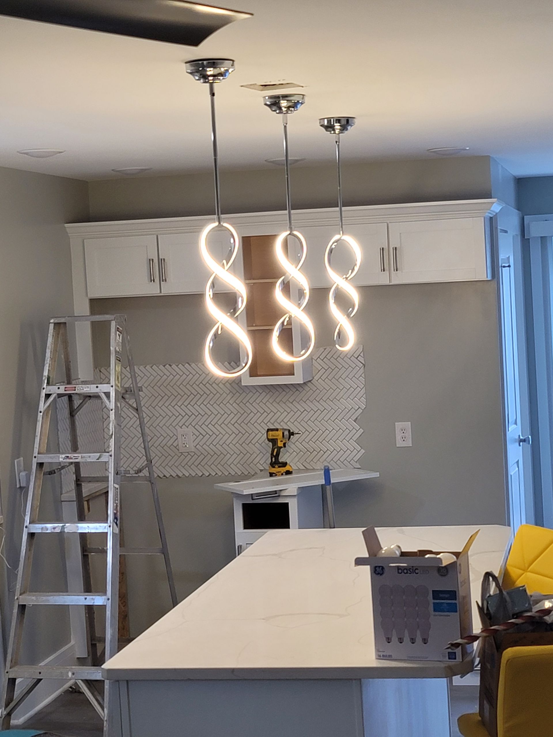 A kitchen is being remodeled with a ladder in the background.