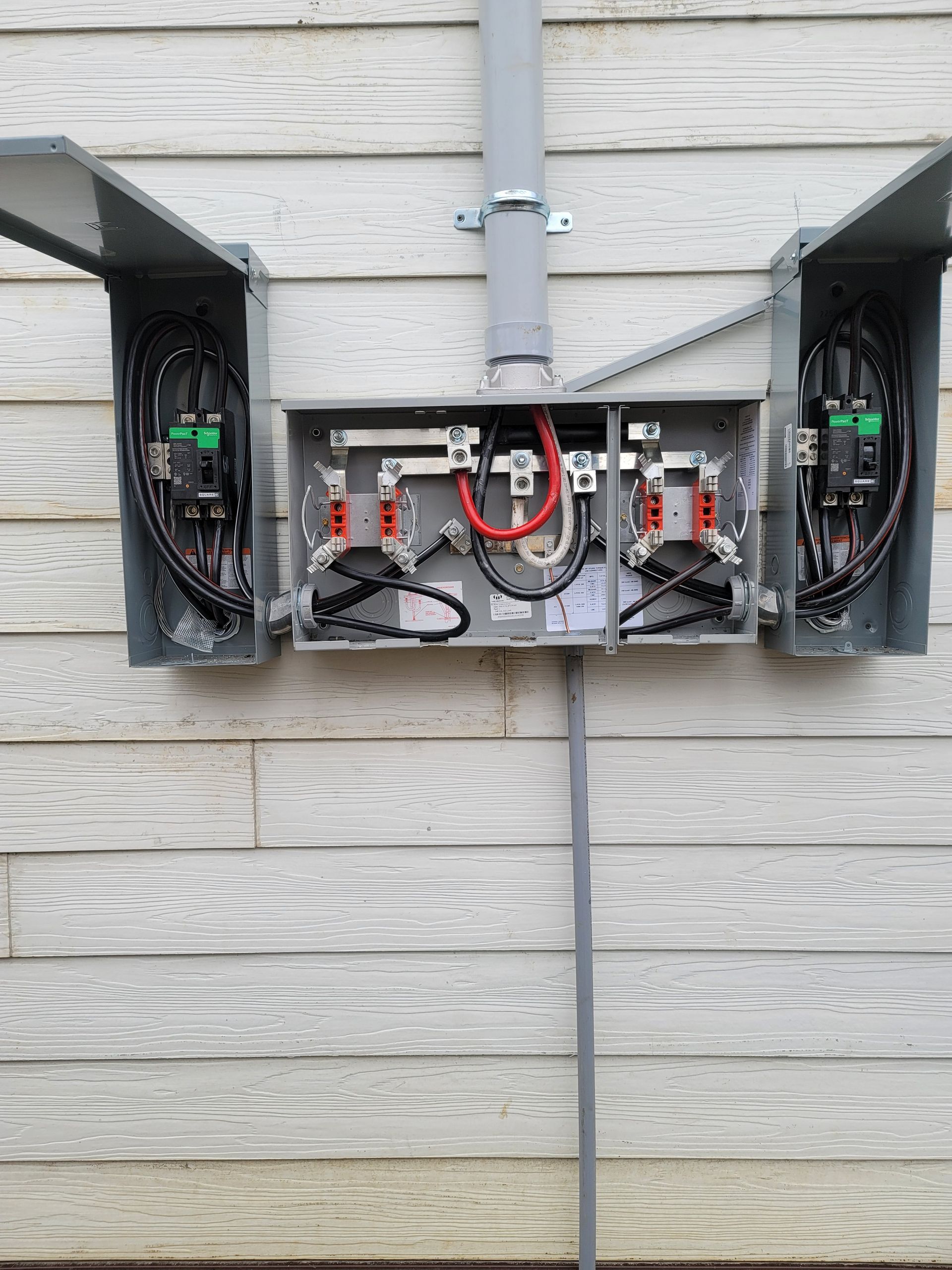 A electrical box is attached to the side of a house.