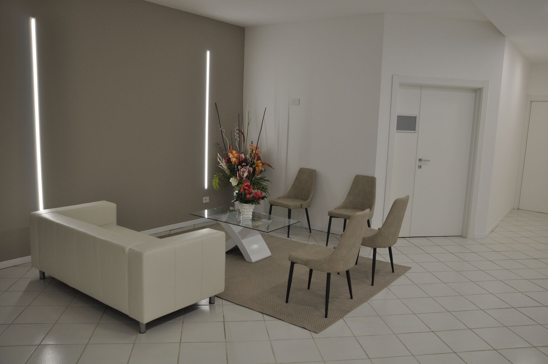 divano bianco e sedie beige in una casa funeraria