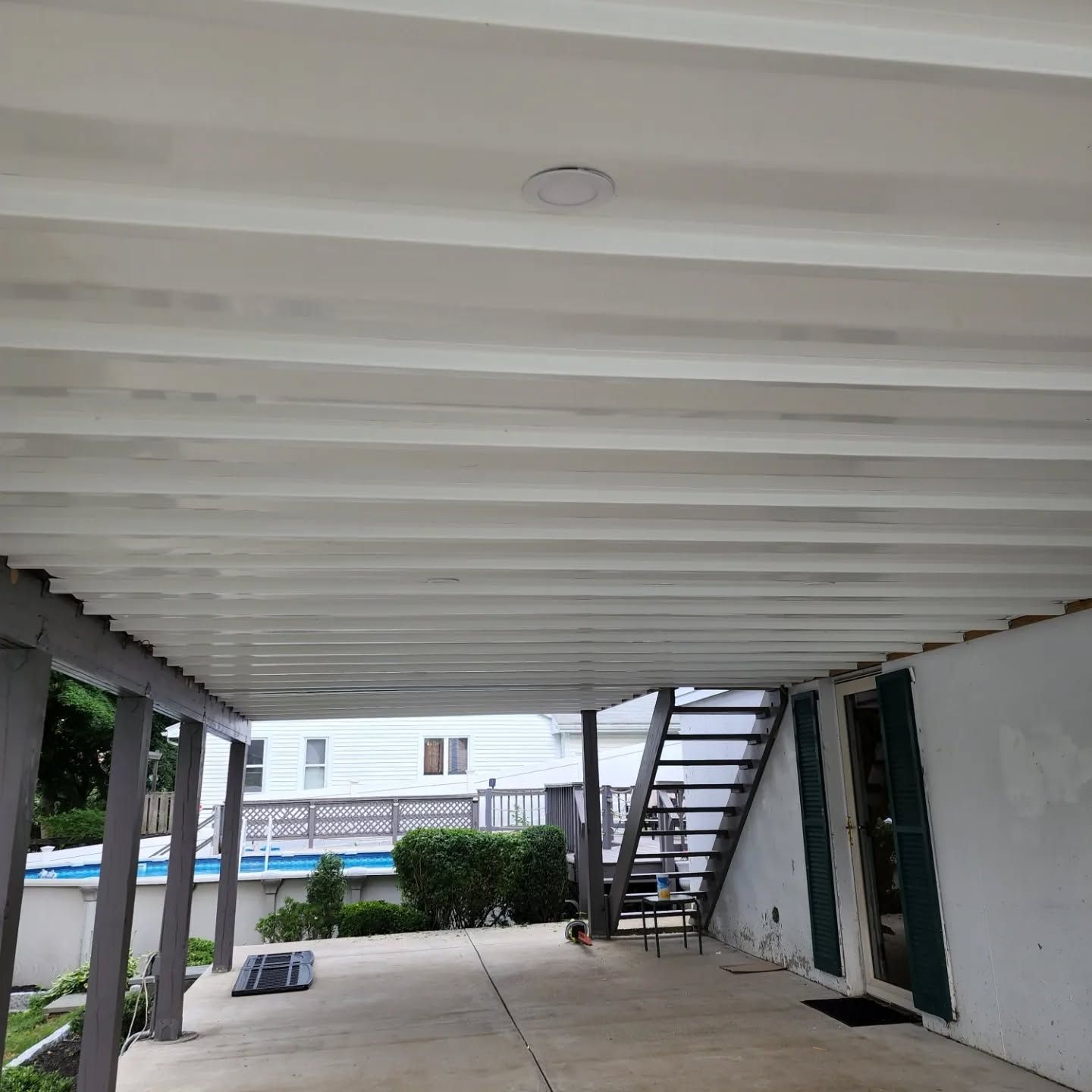 A white deck with stairs leading up to a house