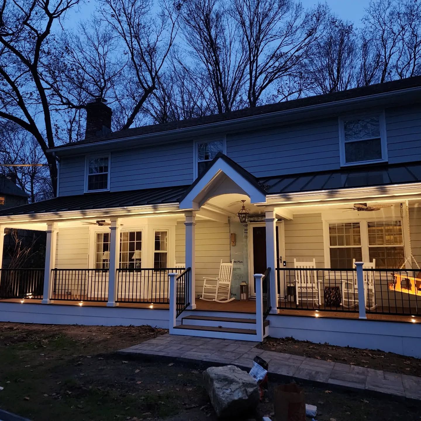 A house with a porch that is lit up at night