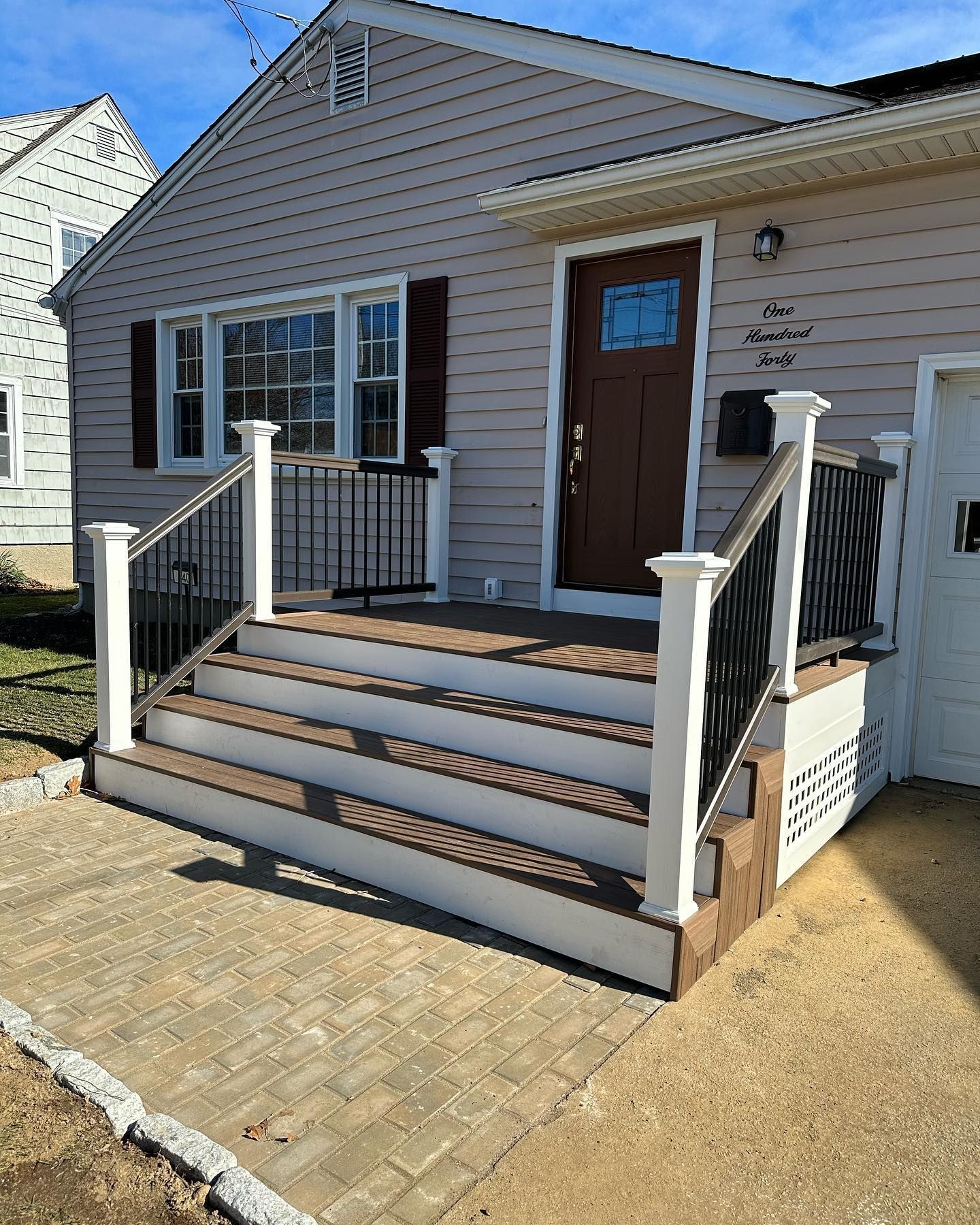 A house with a porch and stairs in front of it.