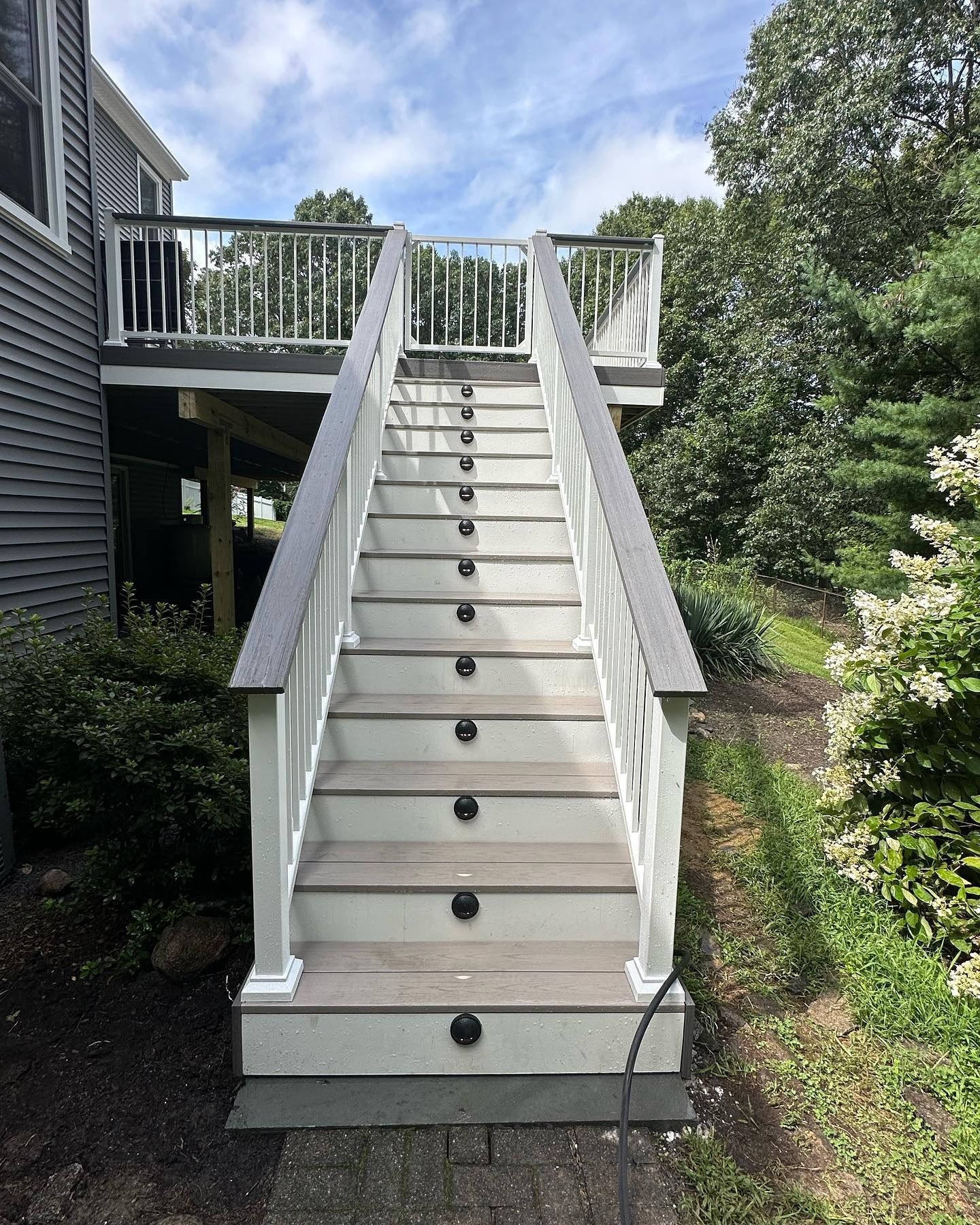 A set of stairs leading up to a deck next to a house.