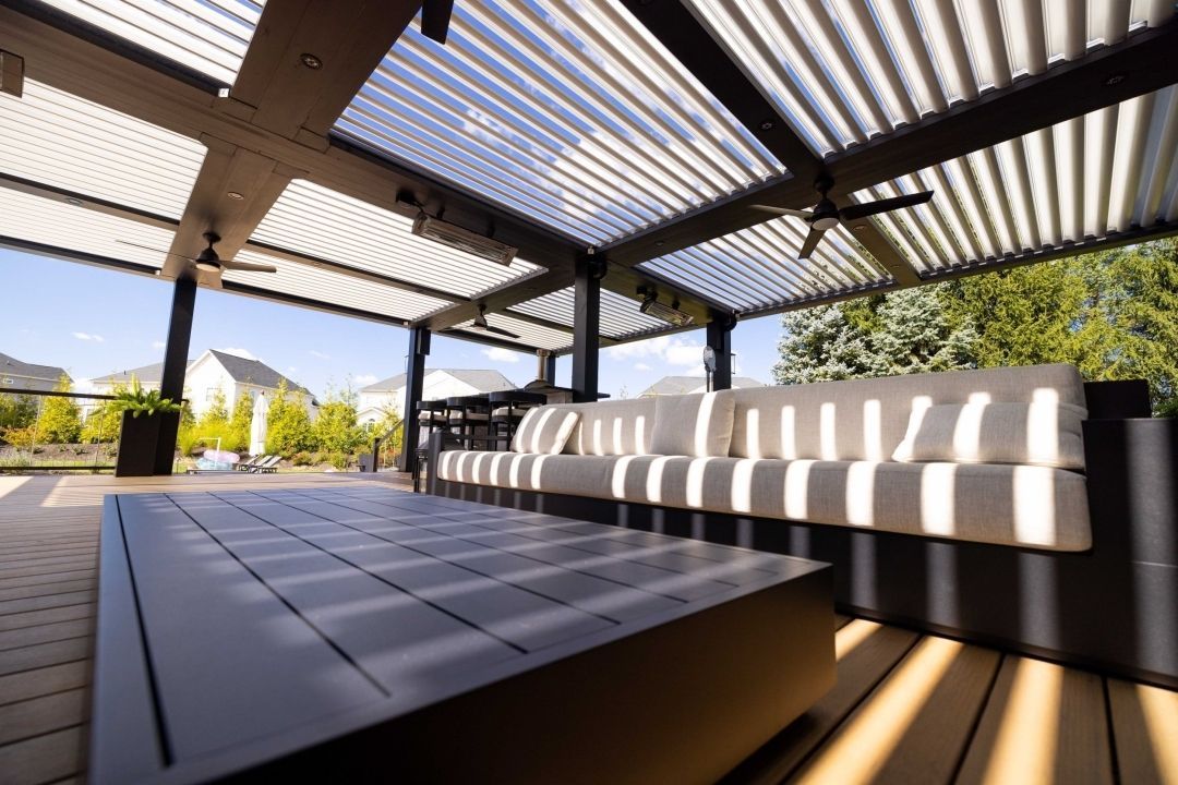 A patio with a couch and a table under a pergola.